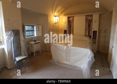 Ein Schlafzimmer mit Schutzfolie im Charles Rennie Mackintoshs Hill House in Helensburgh, wo der National Trust for Scotland die Box um das Haus herum installiert hat. Stockfoto