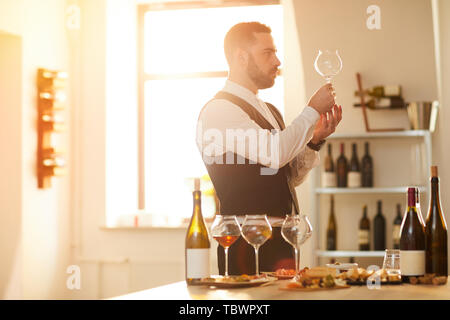 Seitenansicht Portrait von professionellen Sommelier Vorbereitung für die Weinverkostung im Sonnenlicht, kopieren Raum Stockfoto