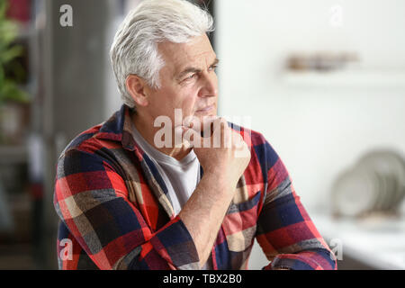 Portrait von nachdenklich älterer Mann in der Küche zu Hause Stockfoto