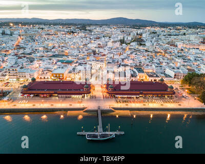 Olhao mit zwei Gebäuden, die durch die Ria Formosa am Abend, Algarve, Portugal Stockfoto