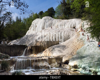 Bagni San Filippo, Italien - 24 April 2019: Menschen Ruhe auf den thermischen Salz Wasserfälle der Mineralquellen von Bagni San Filippo an einem sonnigen Tag. Stockfoto