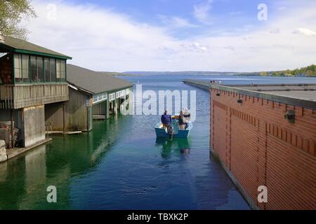 Männer in einem kleinen Fischerboot in Skaneateles See. Die Anlegestelle ist im Hintergrund mitte rechts Stockfoto