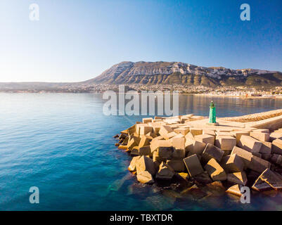 Luftaufnahme von Denia Hafen. Wellenbrecher und ein Leuchtturm im Vordergrund. Die Stadt und den Berg Montgo im Hintergrund. Stockfoto