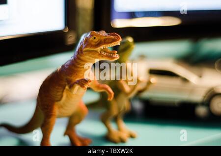 Spielzeug Dinosaurier mit verschwommenen anderen Spielzeugen im Hintergrund Stockfoto