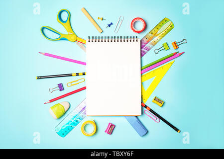 Zurück Hintergrund mit Notepad zu Schule, bunte Stifte, Lineal, Schere, Clips auf Pastell-blaue Hintergrund. Flach, Ansicht von oben, kopieren. Stockfoto