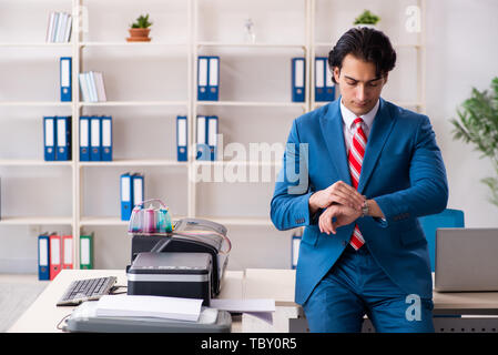Junge Mitarbeiter von Kopien beim Kopieren von Maschine Stockfoto