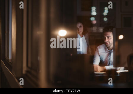 Kollegen zusammen in einem Büro arbeiten bis spät in die Nacht Stockfoto