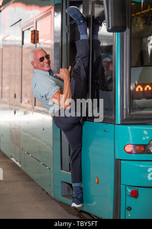 10. Mai 2019 Hessen, Frankfurt/Main: Peter Wirth, bekannt als 'Bahnbabo', der in der vertikalen Spagat mit dem 'Babo Gruß' auf eine Straßenbahn Posen. Der 57-Jährige aus Frankfurt arbeitet seit VGF-Verkehrsbetriebe als Straßenbahnfahrer seit mehr als 30 Jahren. Seit einigen Jahren ist die gut ausgebildete Mann genossen hat Kultstatus, vor allem unter den Jugendlichen und in den sozialen Medien. Foto: Boris Roessler/dpa Stockfoto