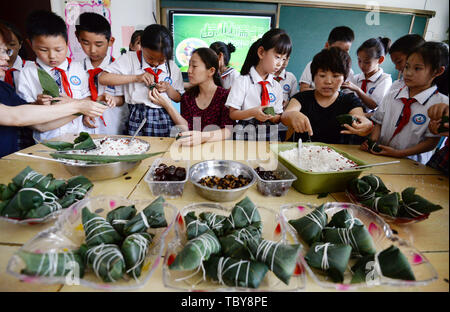 Handan, Handan, China. 4. Juni, 2019. Handan, CHINA - Die Schüler und Schülerinnen lernen, klebrigen Reis Knödel an einer Grundschule in Handan zu machen,ChinaÃ¢â'¬â"¢s Provinz Hebei, die bevorstehende Dragon Boat Festival Kennzeichnung. Credit: SIPA Asien/ZUMA Draht/Alamy leben Nachrichten Stockfoto