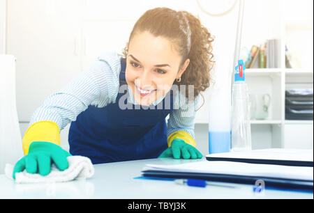 Fröhliche weiblichen professionellen Reiniger in Uniform abstauben in modernen Büro Stockfoto