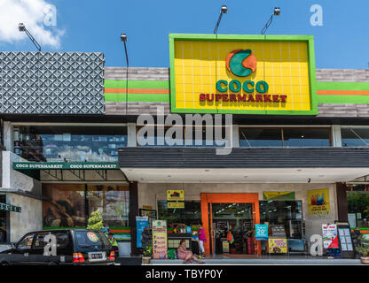 Ubud, Bali, Indonesien - 26. Februar 2019: Downtown Pedang Tegal, Ji. Hanoman Street, im Herzen des Geschäftsviertels. Vor Coco Supermarkt mit großen namensvetter Stockfoto