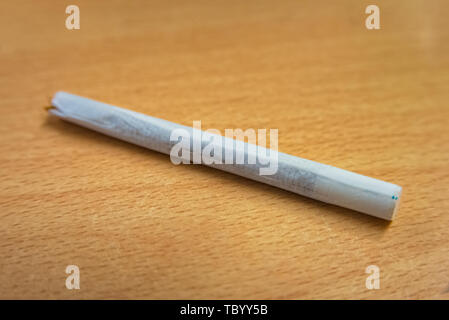 Handgefertigte Zigarette mit Papierfilter liegen auf Holz Stockfoto
