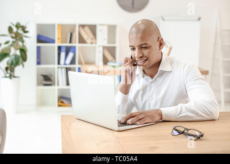 Stattliche Afrikaner - Mann bei der Arbeit am Laptop im Büro Stockfoto