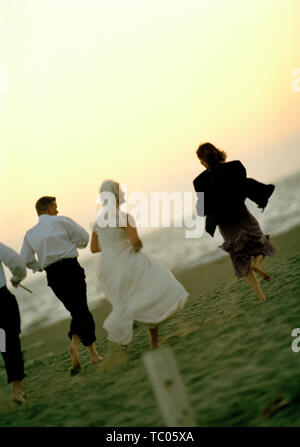 Braut und Bräutigam entlang einem abgelegenen Sandstrand mit Ihrer Hochzeitsfeier. Stockfoto