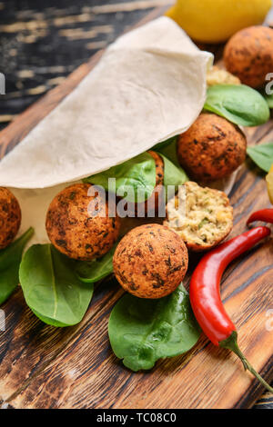 Leckere falafel Kugeln mit Fladenbrot und Spinat auf Holzbrett Stockfoto