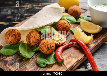 Leckere falafel Kugeln mit Fladenbrot und Spinat auf Holzbrett Stockfoto