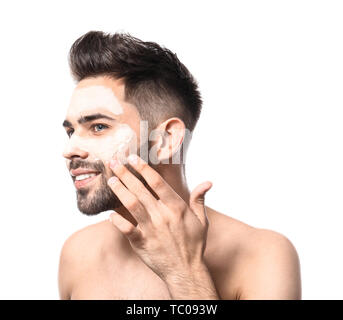 Stattlicher Mann mit Clay Mask auf seinem Gesicht gegen den weißen Hintergrund Stockfoto