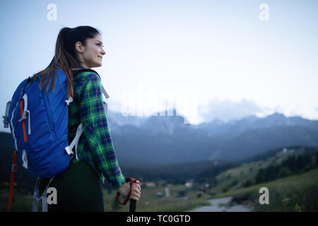 Junge Frau Wanderungen in den Bergen mit schöner Aussicht Stockfoto