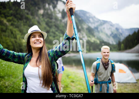 Lächelnd Freunde gehen mit Rucksäcken. Abenteuer, Reisen, Tourismus, Wandern und Menschen Konzept. Stockfoto