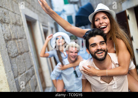 Gerne Freunde huckepack genießen, während die Sehenswürdigkeiten in der Stadt. Stockfoto