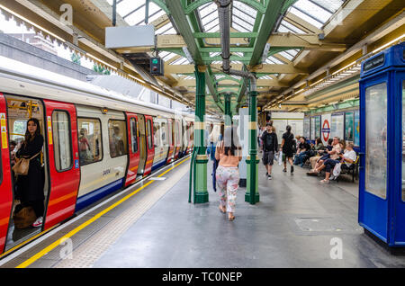 Ein Zug sitzt an der Plattform in der Londoner U-Bahnstation South Kensington. Stockfoto