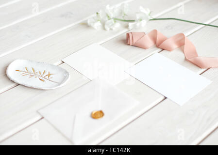 Hochzeit Einladung Geburtstag Geschenkgutschein für ein Spa oder Sorgfalt dekoriert schreiben Karte auf einem weißen Tisch mit einer Niederlassung von weißen Blumen Stockfoto