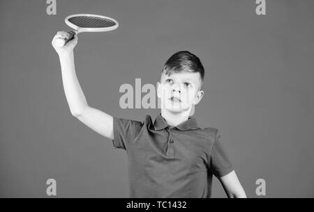 Junge Kind Tennis spielen. Tennis Fähigkeiten zu üben. Kerl mit Schläger genießen Spiel. Zukünftige Meister. Träumen über Sport Karriere. Athlet kid Tennisschläger auf blauem Hintergrund. Tennis Sport und Unterhaltung. Stockfoto