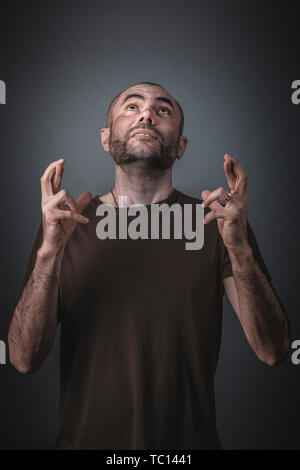 Porträt eines Mannes mit der Suche und hielt seine Finger gekreuzt. Konzept der Hoffnung und des Aberglaubens. Stockfoto