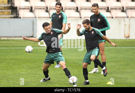 Portugals Pepe (links) und Joao Mountinho Kampf um den Ball wie Cristiano Ronaldo (oben rechts) Uhren auf während des Trainings im Estadio Bessa, Porto. Stockfoto