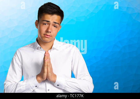 Closeup Portrait von verzweifelten jungen Mann mit gefalteten Händen Stockfoto