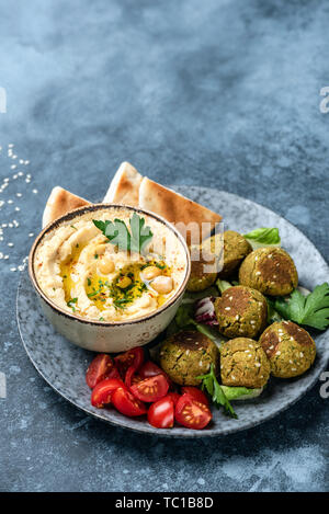 Hummus, hausgemachte gebackene Falafel und gerösteten Fladenbrot. Im arabischen Stil Aperitif-platte auf blauem Hintergrund. Kopieren Sie Platz für Text Stockfoto