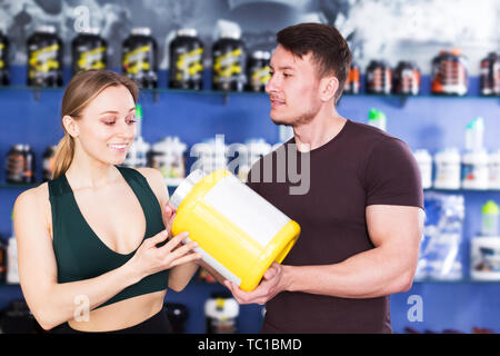 Junge sportliche Personen, die Sport Ernährung Produkte im Fachgeschäft. Fokus auf den Menschen Stockfoto