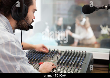 Toningenieur bei Mischen Panel im Radio Studio, Controlling Niveau und die Qualität des Klangs auf der Luft arbeiten Stockfoto