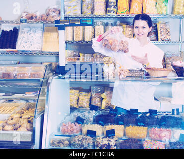 Glückliche Frau Verkauf von Cookies und anderen Füllungen Stockfoto