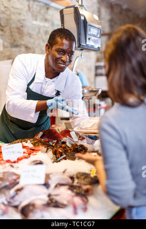 Portrait von Verkäufer in Schürze mit weiblichen Kunden frischen Fisch und Meeresfrüchte shop Stockfoto