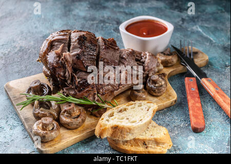 Gegrilltes Lamm Bein mit Pilzen, Gemüse, Gewürze auf einem Schneidebrett. Halal Fleisch und Lebensmittel Stockfoto