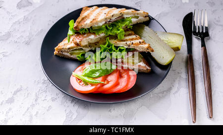 Leckere Sandwiches mit Rindfleisch, Salat und Käse auf einem Schild auf einen konkreten Hintergrund. Stockfoto