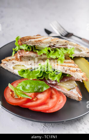 Close-up leckere Sandwiches mit Rindfleisch, Salat und Käse auf einem Schild auf einen konkreten Hintergrund. Stockfoto