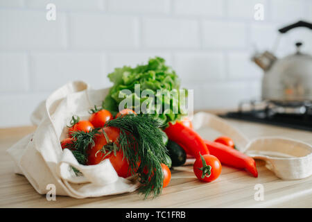 Frisches Grün und Rot Bio Gemüse in Leinen eco Beutel auf den Tisch in der Küche. Gesunder Lebensstil Stockfoto