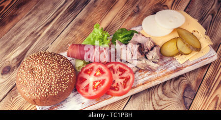 Essen banner Hamburger Zutaten. Fleisch, Käse, Tomaten, Zwiebeln, Gurken, Salat und Speck. Stockfoto