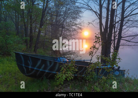 Die Sonne beginnt über ein altes Fischerboot am Ufer der Wildnis See im nördlichen Wisconsin ruhen zu steigen. Stockfoto