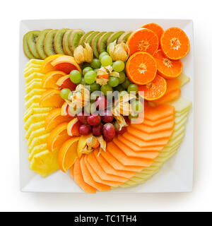 Mischung aus frisch geschnittenen Tropischen und Zitrusfrüchte auf weißem Quadrat Keramik Schüssel auf weiß von oben getrennt angeordnet. Stockfoto