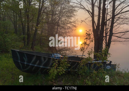 Die Sonne beginnt über ein altes Fischerboot am Ufer der Wildnis See im nördlichen Wisconsin ruhen zu steigen. Stockfoto