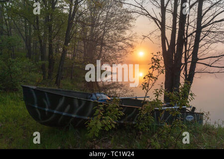 Die Sonne beginnt über ein altes Fischerboot am Ufer der Wildnis See im nördlichen Wisconsin ruhen zu steigen. Stockfoto