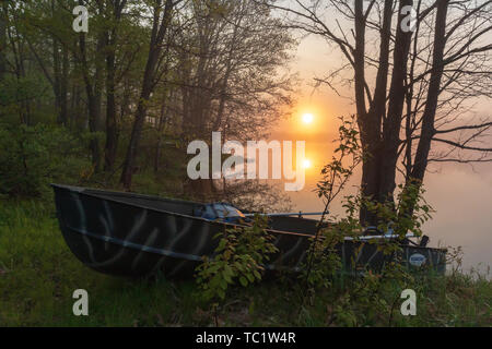 Die Sonne beginnt über ein altes Fischerboot am Ufer der Wildnis See im nördlichen Wisconsin ruhen zu steigen. Stockfoto