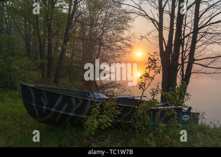 Die Sonne beginnt über ein altes Fischerboot am Ufer der Wildnis See im nördlichen Wisconsin ruhen zu steigen. Stockfoto