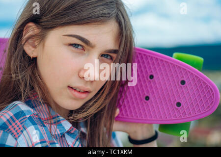 Hipster Mädchen mit Penny. Städtische Szene, Leben in der Stadt. Skateboard sport Hobby. Sommer Aktivität. Kunststoff Mini Cruiser board. Feder. bereit sein, darauf zu reiten Stockfoto
