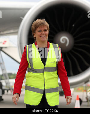 Erste Ministerin Nicola Sturgeon auf der Asphaltbahn am Flughafen Edinburgh, als sie offiziell eine Terminalerweiterung eröffnet. Millionen £80 wurden in den Ausbau des Terminals investiert, der neue internationale und nationale Ankunftshallen und Gepäckabgabebereiche, neue Gates und Sitzbereiche, neue Flugzeugstände, neue Lounges und neue Einzelhandelsgeschäfte sowie Lebensmittel- und Getränkestände bietet. Stockfoto