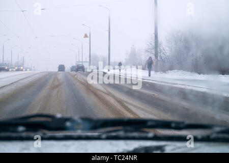 Eis auf der Straße. Auto Fahrten auf der Autobahn in die Stadt. Schnee und Schnee Sturm schlechtes Wetter Stockfoto