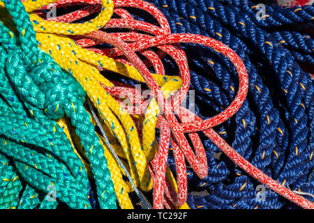 Grün, Gelb, Orange und Blau die Seile in ein Chaos. Verschiedene farbige Seile. Stockfoto